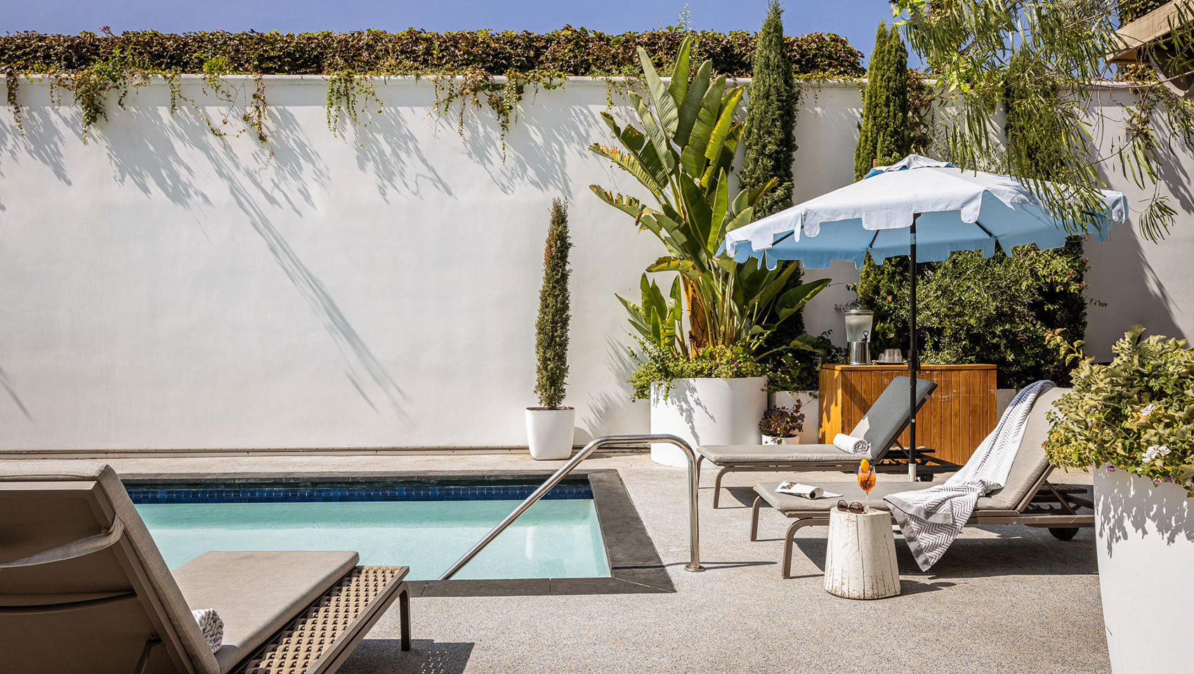 La Peer Outdoor Pool with pool chairs and umbrella