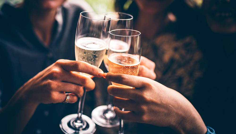 3 hands cheers with glasses of sparkling wine