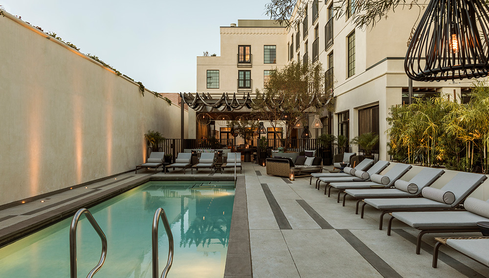 La Peer pool deck with lounge chairs looking toward the hotel